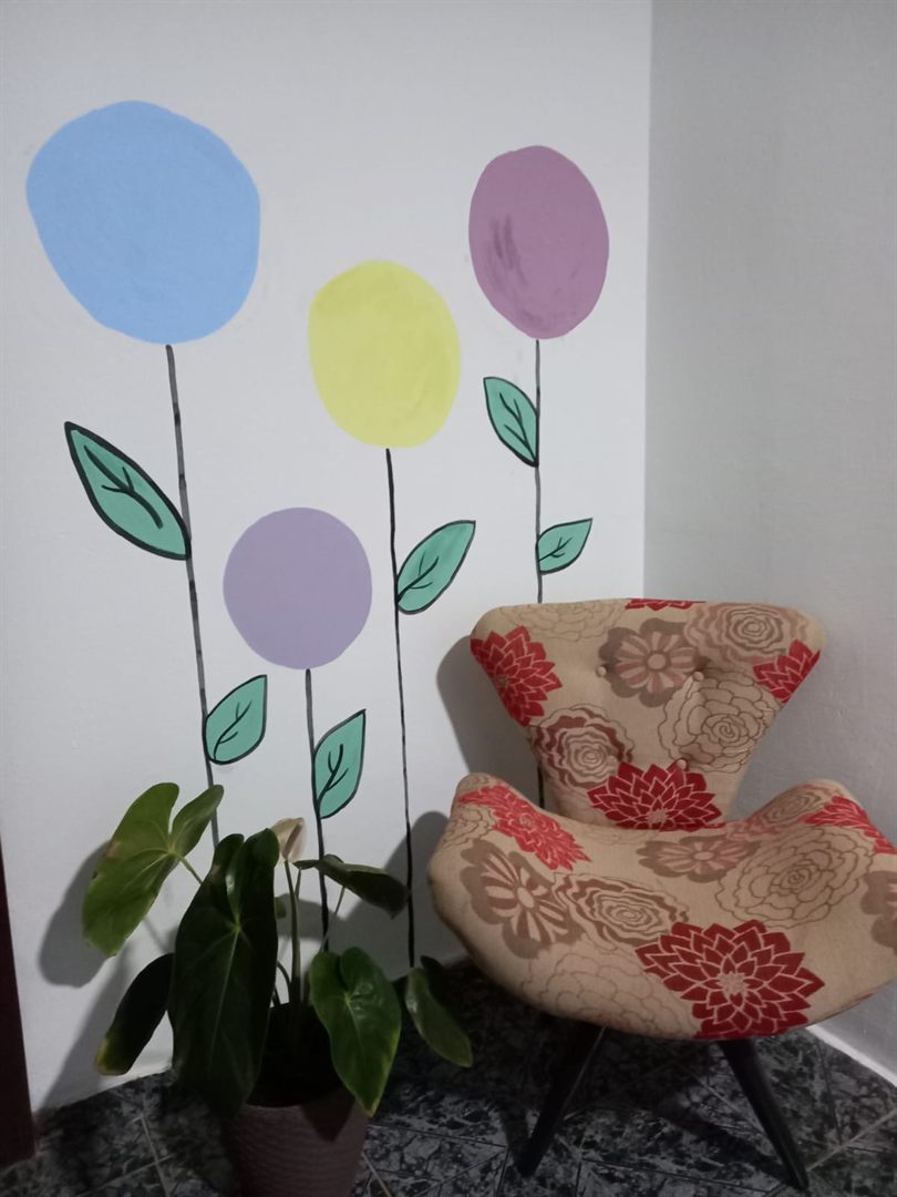 Ambiente de acolhimento do Espaço Florescer, com poltrona e parede decorada com flores