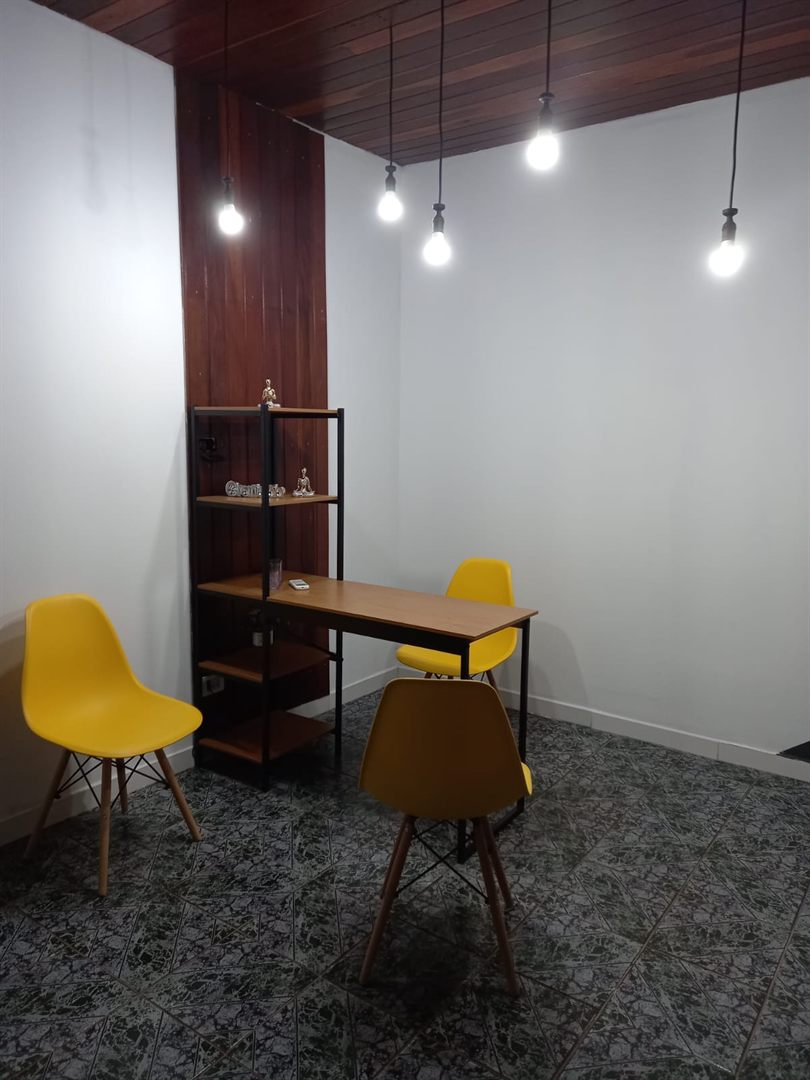 Sala de atendimento com mesa de madeira e cadeiras