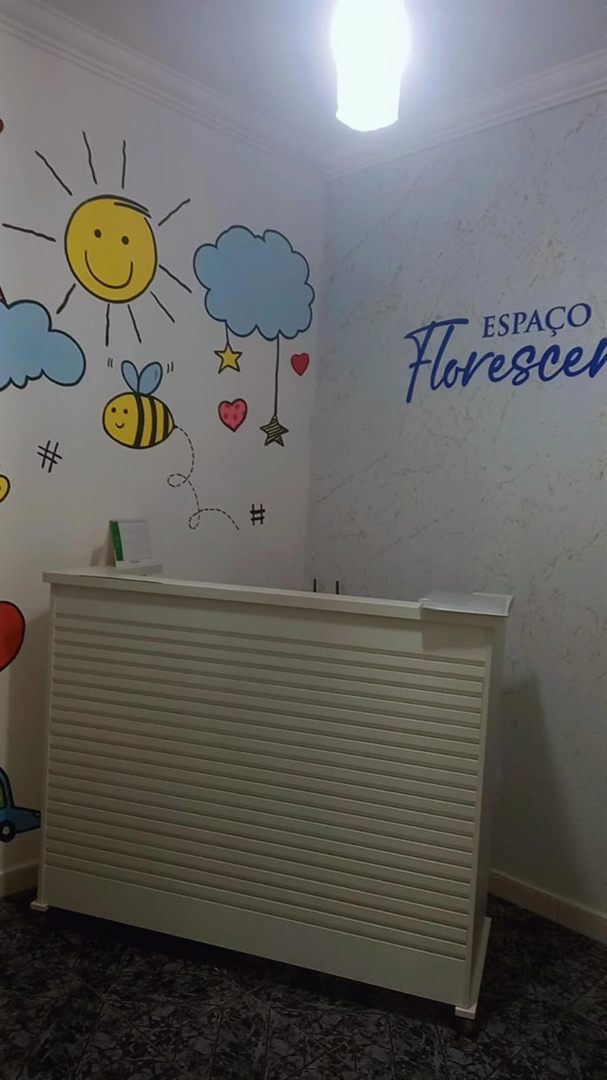 Recepção do Espaço Florescer com a marca pintada na parede
